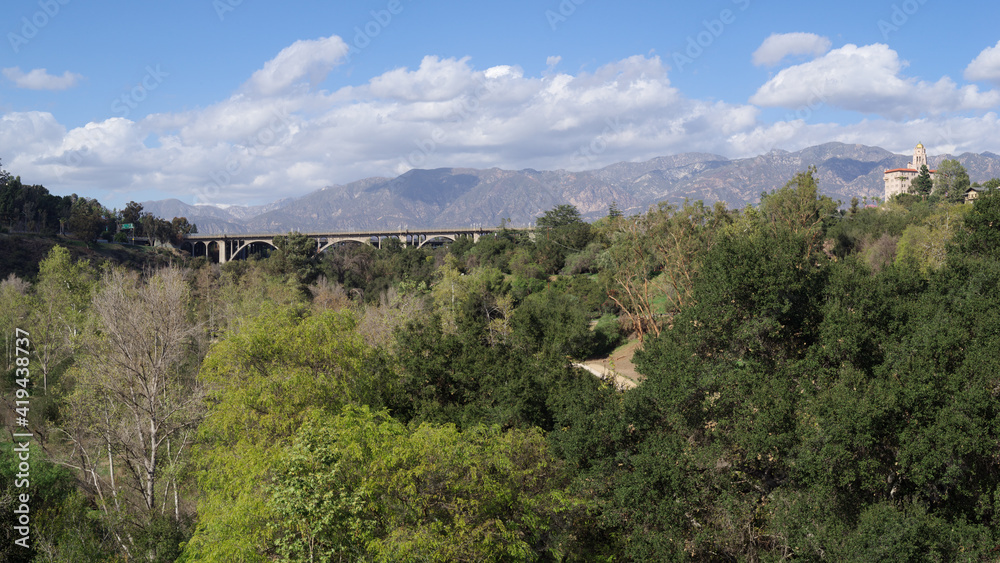 Panoramic view of the Arroyo Seco, the Colorado Street Bridge, and the Richard Chambers Courthouse against the San Gabriel Mountains in Pasadena.