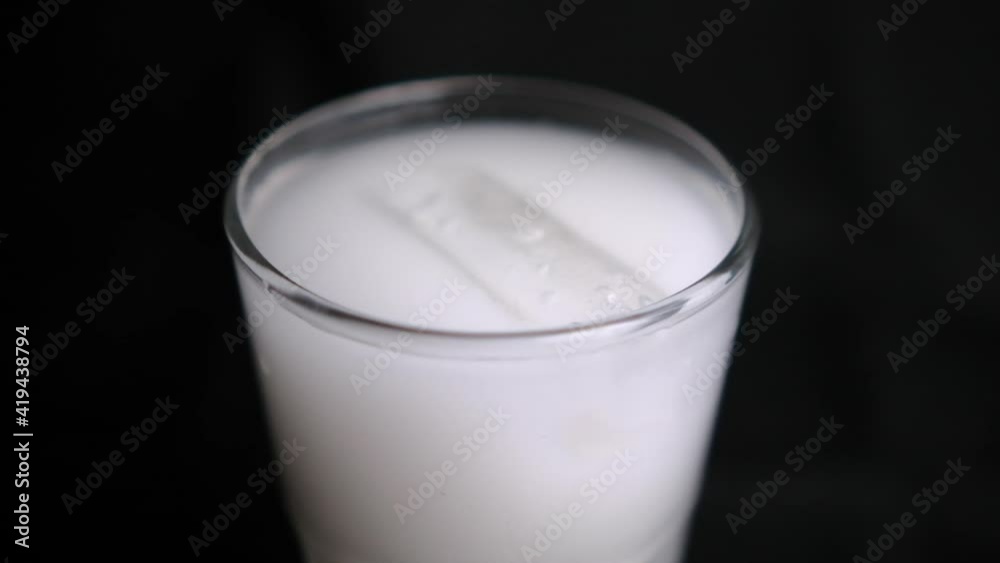 Glass of traditional Mexican horchata water with black background Glass of traditional Mexican horchata water with black background