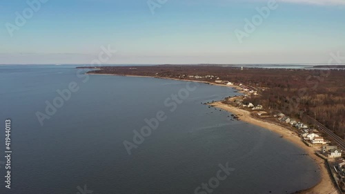 Wallpaper Mural a high angle view over the calm waters by an empty beach, on a day with blue skies. The drone camera truck right over to the beach. Torontodigital.ca