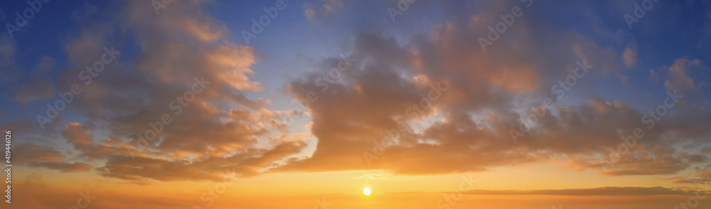 Obraz premium panoramic view from an airplane on a beautiful saturated sunrise above the clouds in red and orange shades