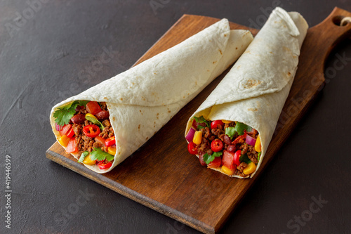 Burritos with meat, beans, corn, tomatoes, onions and chilli. Mexican food. Recipe.