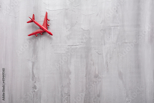 Red passenger toy plane on a gray background. Vacation concept.