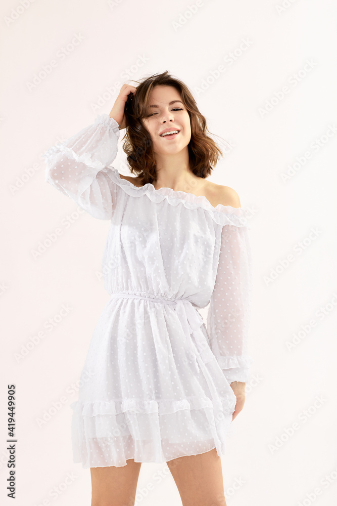 smiling beautiful young brunette woman in white dress dancing. soft light. spring time smiling beautiful young brunette woman in white dress dancing. soft light. spring time