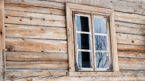 Boarded up windows on the old wooden wall of the house. Carving adorns the old window. Image for design. Countryside concept.
