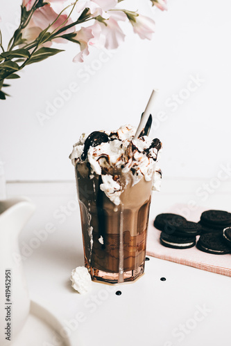 sweet yummy frappe drink with chocolate cookies on whipped cream in light kitchen