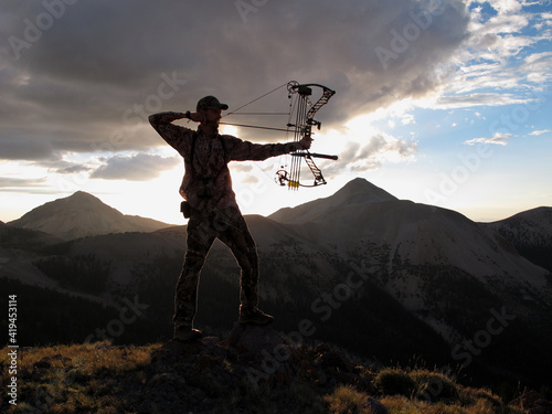 modern bowhunter silhouette with mountains and sky