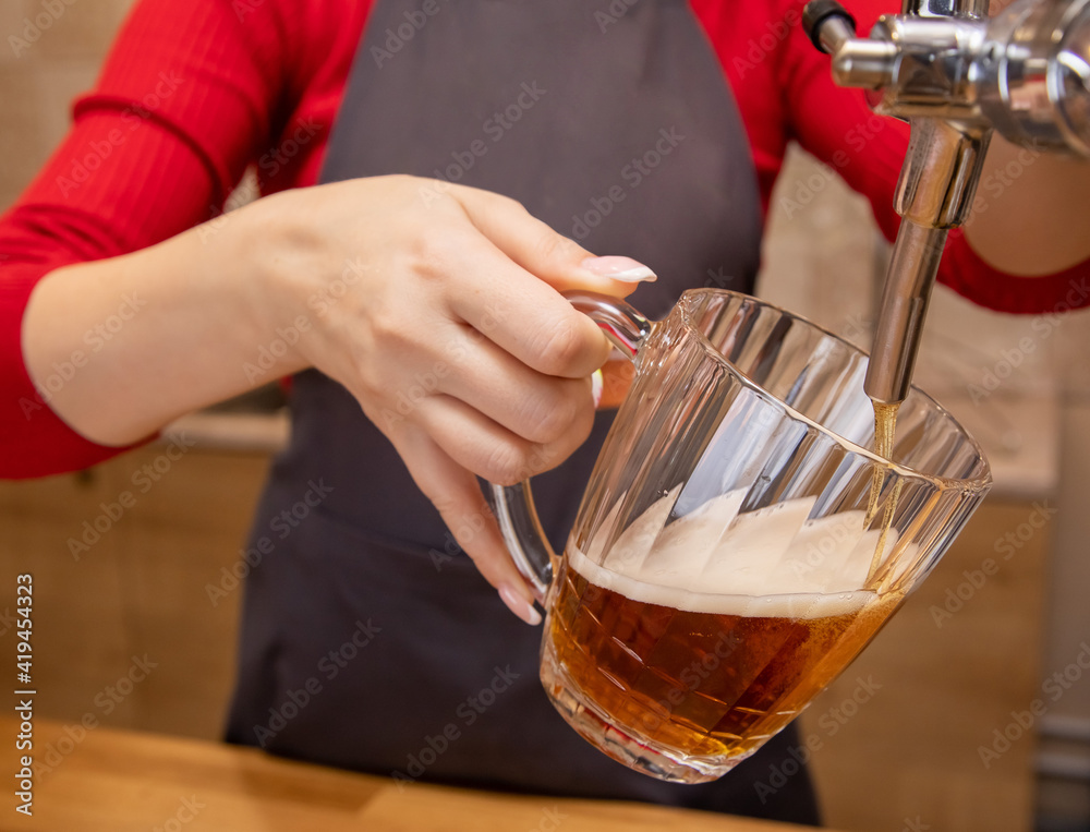 barman hands at beer tap pouring a draught lager beer serving in a restaurant or pub barman hands at beer tap pouring a draught lager beer serving in a restaurant or pub