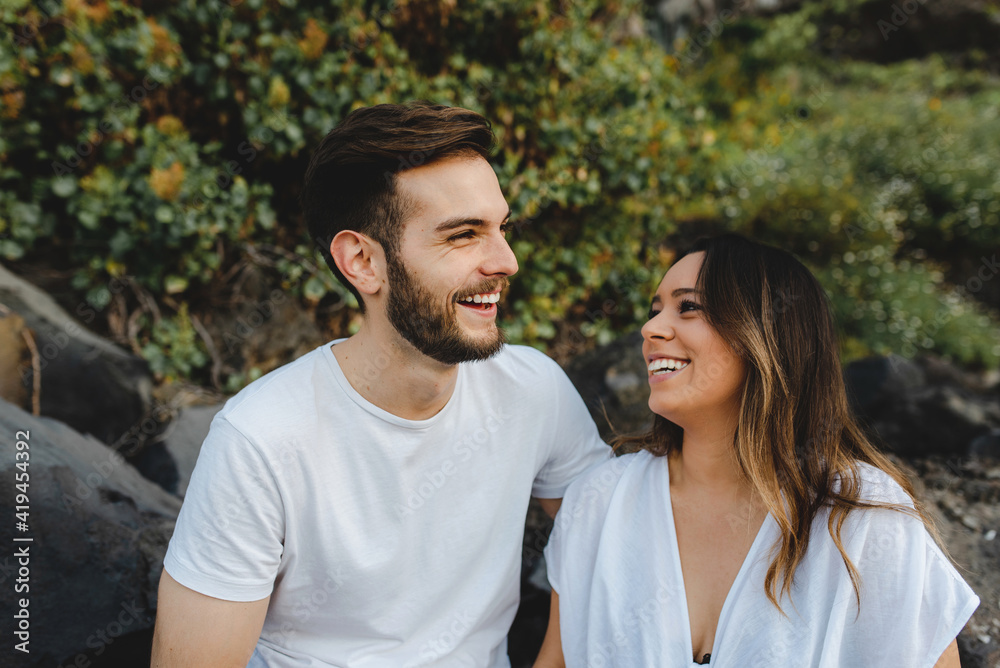 Happy couple standing looking at each other while enjoying summer holidays on Tenerife island Happy couple standing looking at each other while enjoying summer holidays on Tenerife island