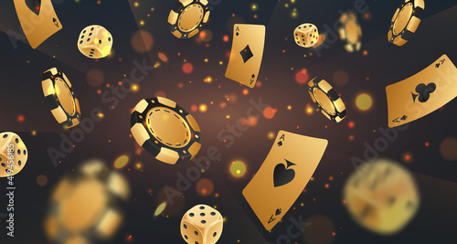 Fotografia Falling golden poker chips, tokens, dices, playing cards on black background with gold lights, sparkles and bokeh