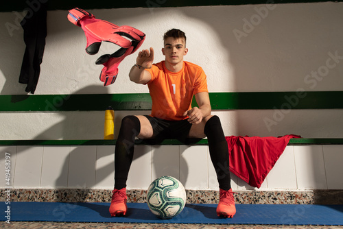 A football player in dressing room with sports uniform photo