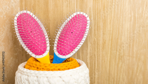 two colored hair combs in a basket in the bathroom. Hygiene and healthy lifestyle concept. Copy space