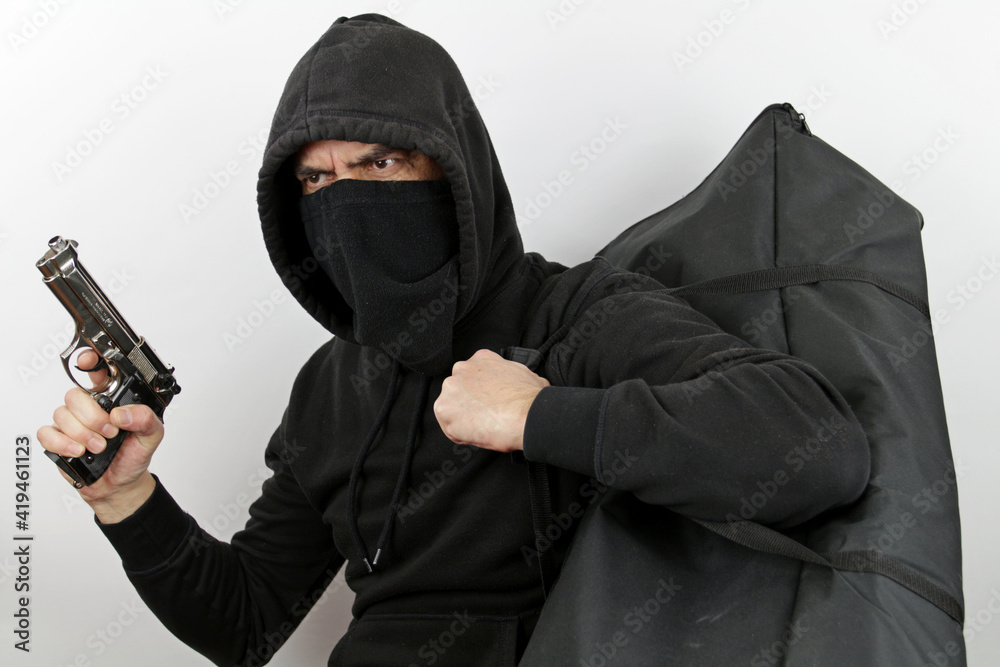 Robber with black mask, gun and a bag of money, isolated on white background. Robber with black mask, gun and a bag of money, isolated on white background.