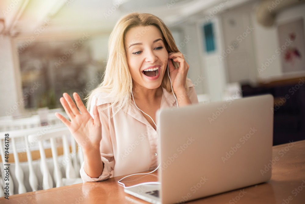 Young woman in cafe sitting having video call waving to camera smiling cheerful Young woman in cafe sitting having video call waving to camera smiling cheerful