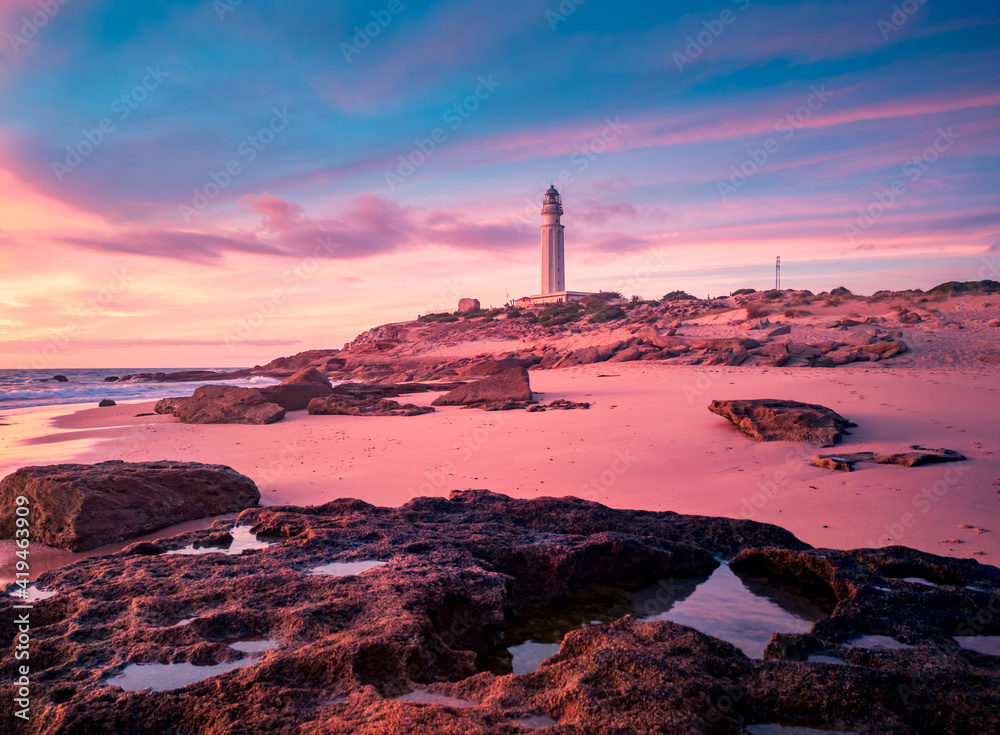 Magnificent view of lighthouse located on hill near sea against colorful sundown sky in Cadiz Magnificent view of lighthouse located on hill near sea against colorful sundown sky in Cadiz