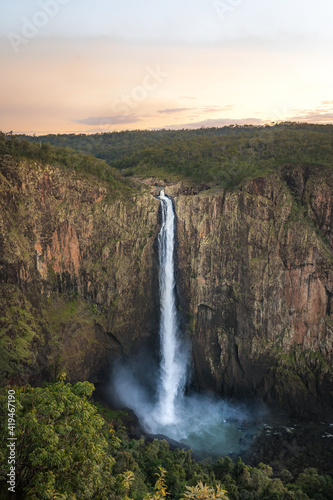 Spectacular aerial view of powerful Wallaman Falls flowing through rocky cliff in Girringun National Park covered with lush tropical vegetation in Queensland photo