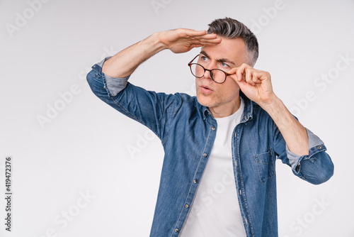 Handsome caucasian man looking far away isolated over white background