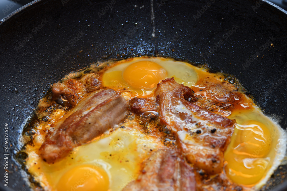 Pieces of fried meat cooked with scrambled eggs in a pan. Pieces of fried meat cooked with scrambled eggs in a pan.