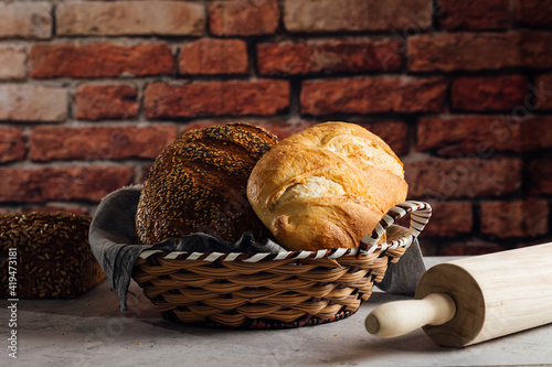 Delicious wholegrain bread in straw basket on table