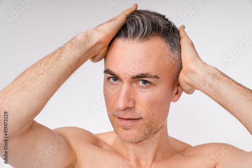 Close up portrait of a naked mature macho man isolated in white background