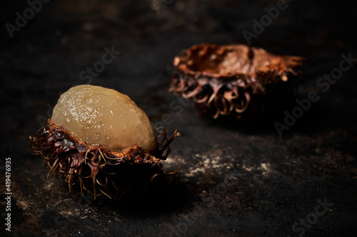 Macro view of rambutan on dark rustic wooden background photo
