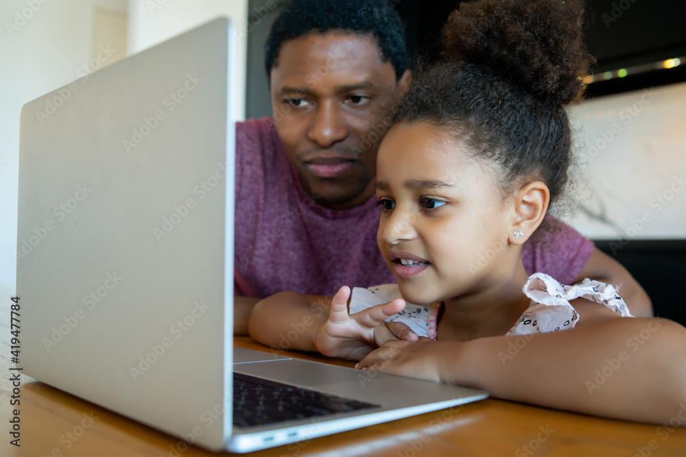 A father helping his daughter with homeschool. A father helping his daughter with homeschool.