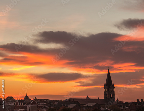 dramatic sunrise on the church steeple and rooftops of Baltimore City in Maryland