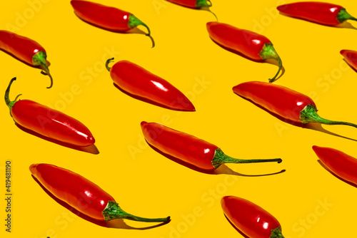 From above of fresh ripe chili peppers on yellow background photo