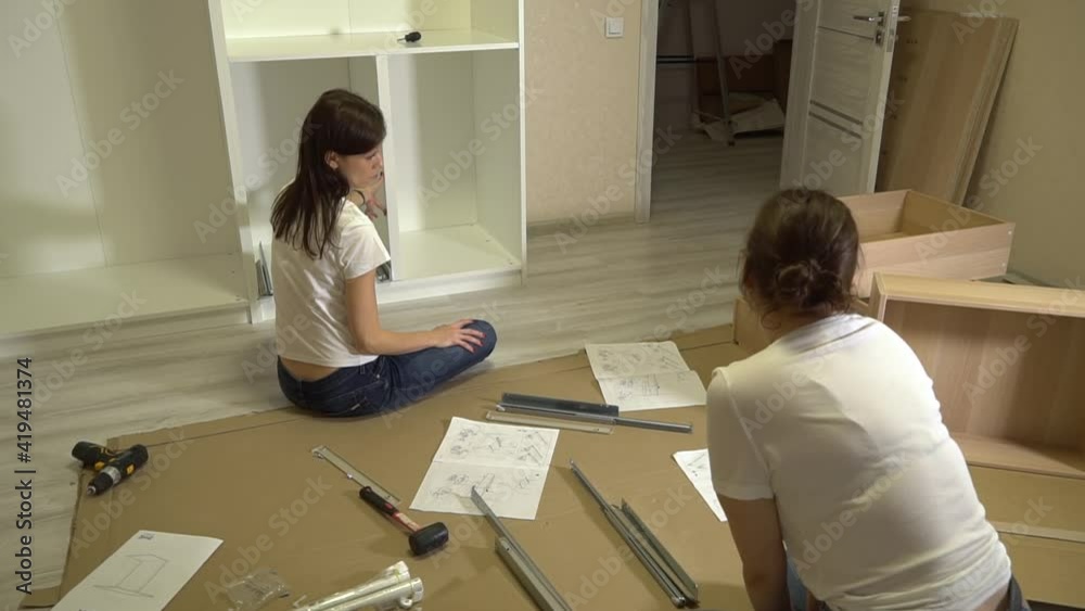 Women self assembling furniture together. Moving in new house Women self assembling furniture together. Moving in new house
