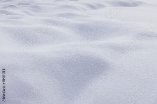 Textured backdrop of snowy terrain with white bumpy surface in winter season in daylight photo
