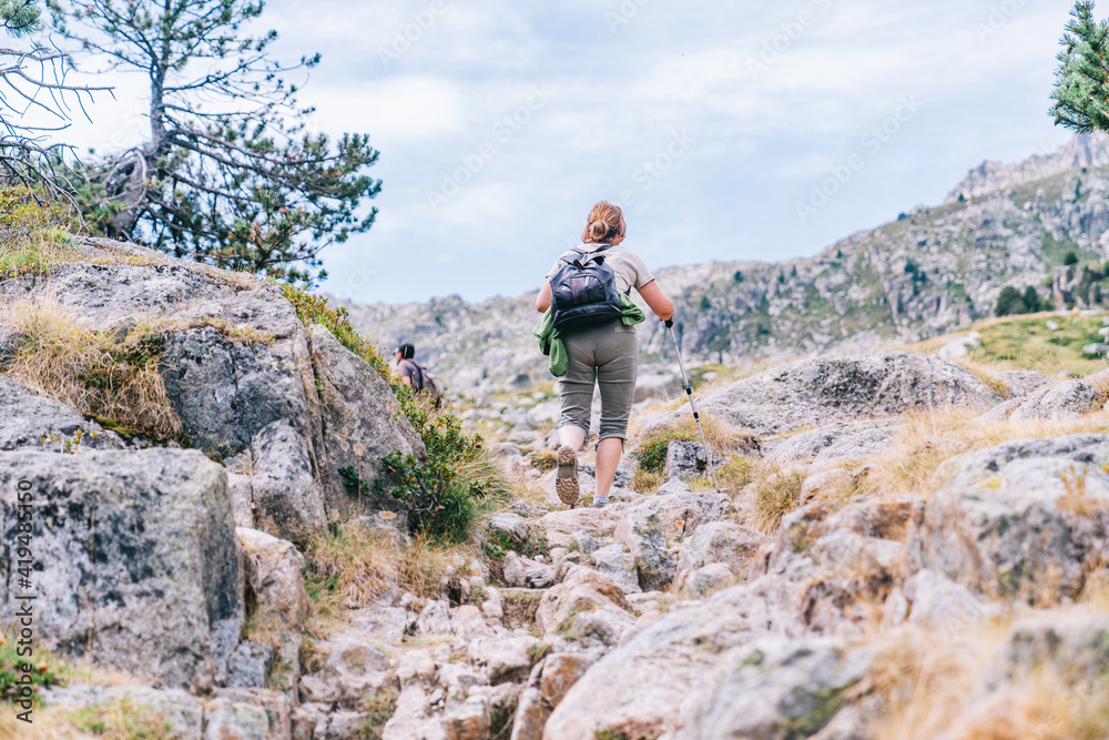 Back view of anonymous backpackers walking on mountain during summer trip Back view of anonymous backpackers walking on mountain during summer trip