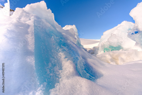 Türkisblaue Eisgebilde auf zugefrorenem Bergsee