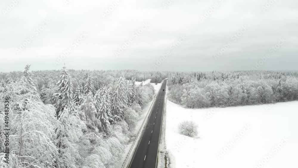 Aerial top down view on winter freeway road. Asphalt road in the frozen forest Aerial top down view on winter freeway road. Asphalt road in the frozen forest