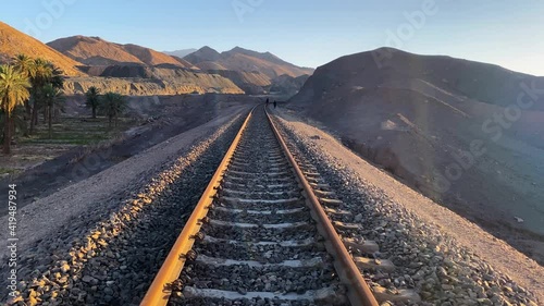 Move on the Railway in Sunset Time in Iran Middle East Asia Persia Yazd Ardakan Near the Remote Abandoned Oasis Village with Mountains Gold Mine Iron Mine and Palm Tree Garden in The Lut Desert photo