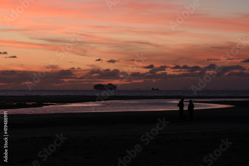 silhouettes of couple and boats on sunset beach Cadzand © henkbouwers