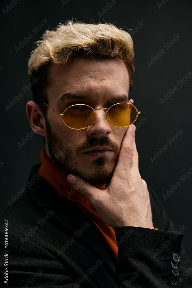 portrait of an attractive blond man gesturing with his hands on a dark background portrait of an attractive blond man gesturing with his hands on a dark background