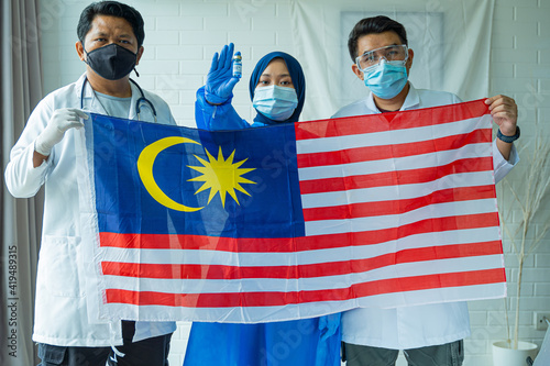 Malaysian people wearing medical suit holding Flag