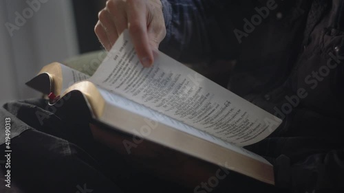 Man slowly flipping bible pages photo