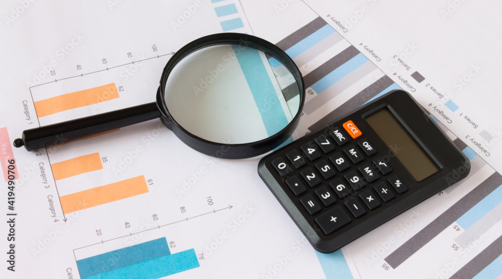 Calculator with magnifying glass on the diagrams Calculator with magnifying glass on the diagrams