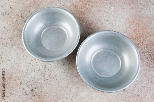 Old metal bowls on concrete background.