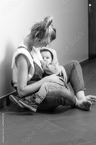 mom breastfeeds the baby, baby sucks breast milk in mom's arms, lifestyle, breastfeeding, black and white photo