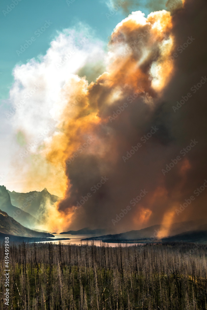 A  dramatic huge clouds of smoke billowing into the sky during a summer forest fire in Reynolds Creek in St.Mary's Lake in Glacier National Park in Montana. 