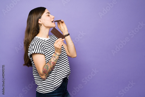 Hispanic woman taking a bite out of chocolate