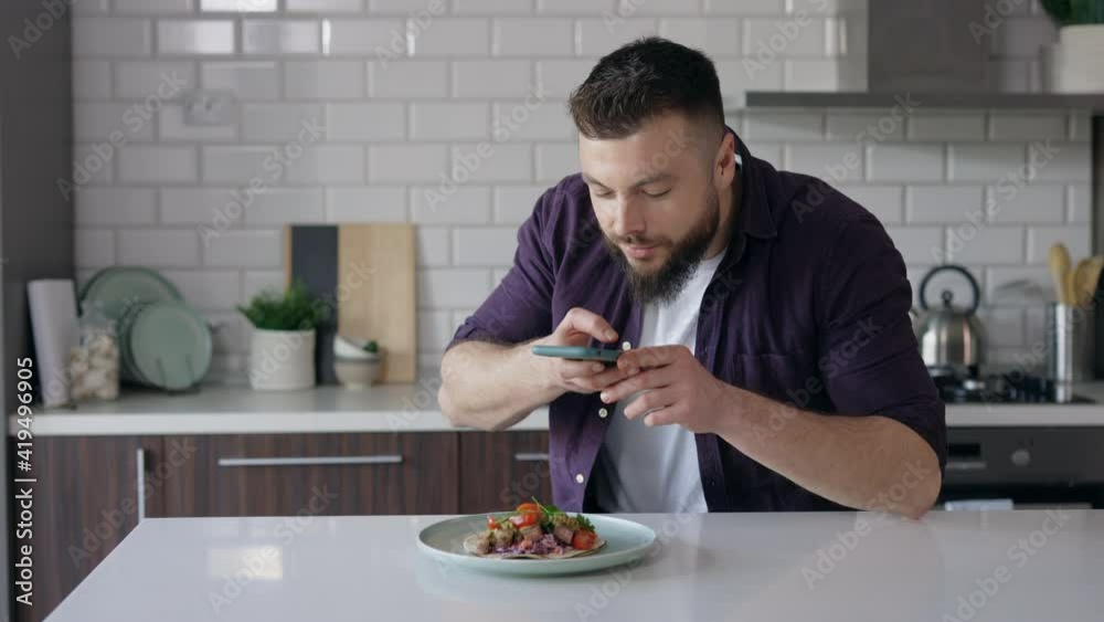 Portrait of Handsome Young Man Photographing Food using a Smartphone at Home in the Kitchen in Daylight, Food Photography and Food Blogging Concept, Phone Photography of Homemade Fresh Tacos, Handheld Portrait of Handsome Young Man Photographing Food using a Smartphone at Home in the Kitchen in Daylight, Food Photography and Food Blogging Concept, Phone Photography of Homemade Fresh Tacos, Handheld
