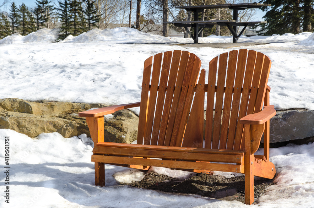 Adirondack double chair in the park, very early spring with still lots of snow on the ground