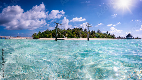 Fototapeta Naklejka Na Ścianę i Meble -  Beautiful view of a hammock over turquoise sea in front of a tropical paradise island in the Maldives, Indian Ocean