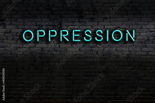 Night view of neon sign on brick wall with inscription oppression photo
