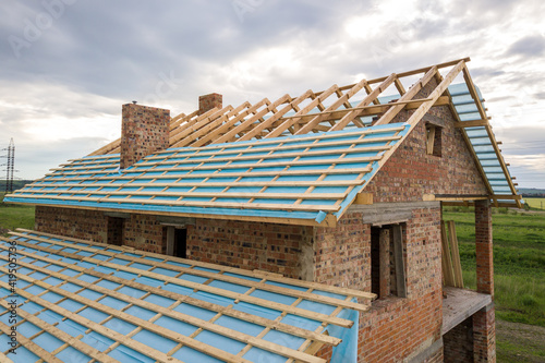 Tableau sur toile Aerial view of a brick house with wooden roof frame under construction