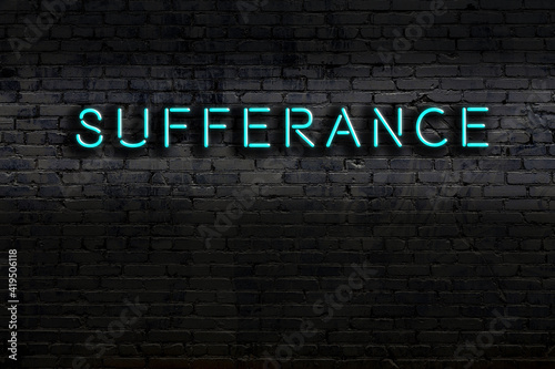 Foto Neon sign. Word sufferance against brick wall. Night view
