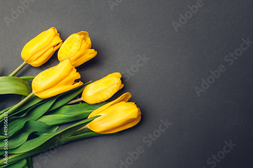 Spring yellow flowers. Bouquet of tulips on grey background. Present, gift for Mother's day. Space