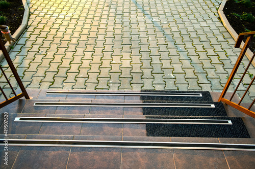 Closeup of ceramic tiles covering porch stairs with rubber anti slippery stripes on it.